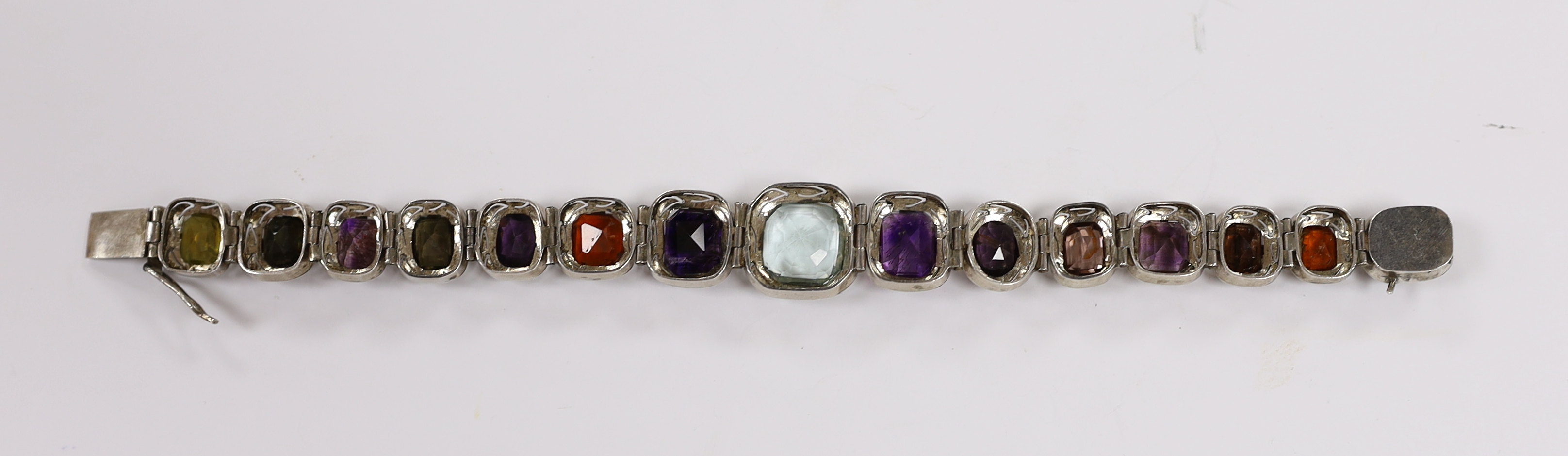 A white metal (tests as silver) and graduated multi gem set bracelet, 17.5cm